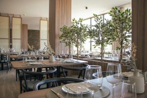 a restaurant with wooden tables and chairs with wine glasses at Quinta do Roso - Douro Wine Estate - by FERO in Lamego