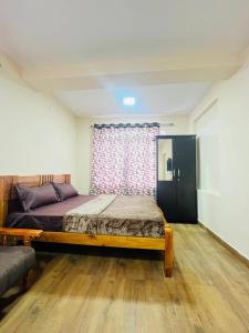 a bedroom with a large bed and a window at Green Hills Cottage in Aravankādu
