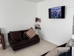a living room with a couch and a flat screen tv at In Wotoch in Cancún