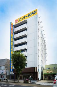 un bâtiment avec un panneau sur son côté dans l'établissement Super Hotel Mito, à Mito