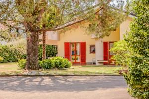 a house with red doors and a tree at Large lakeside villa in Lesa