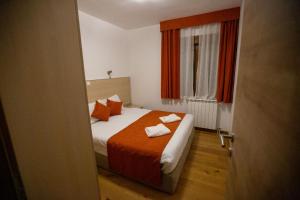 a bedroom with a bed with an orange blanket at Orange stan in Žabljak