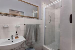 a white bathroom with a sink and a shower at Santa Stay in Stellenbosch