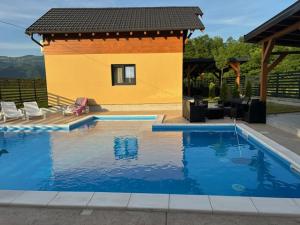 a swimming pool in front of a house at Zelena reka 4 in Vrhpolje