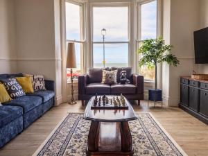 a living room with a couch and a table with chess at Sea View, East Parade in Llandudno