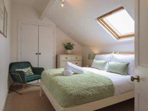 a bedroom with a bed and a chair at Sea View, East Parade in Llandudno