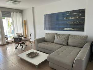 a living room with a couch and a table at Atico en Almadraba in Benicàssim