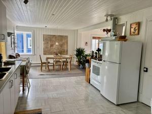 a kitchen with a white refrigerator and a table at Maison du Photographe in Bic