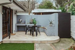 a patio with a table and chairs in a backyard at Santa Stay in Stellenbosch