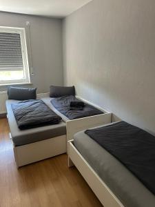two beds in a small room with a window at Haselbach Living in Ehekirchen +13 photos