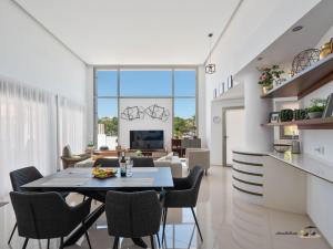 a dining room and living room with a table and chairs at Villa Dominica in Rojales