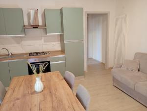 a kitchen and living room with a table and a couch at Casa Marina mare e relax in Marina Palmense