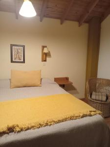 a bedroom with a bed with a yellow blanket at Cabañas LaMaria in Coronel Suárez +7 photos