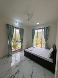 a bedroom with a bed and a large window at kailasa Villa in Karjat