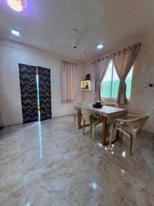 a dining room with a table and chairs and windows at kailasa Villa in Karjat