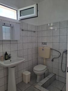 a bathroom with a toilet and a sink at Studios Elena Central in Limenaria