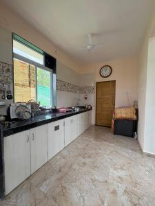 a kitchen with a sink and a clock on the wall at kailasa Villa in Karjat +13 photos