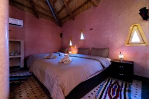 a bedroom with a bed with two towels on it at Gîte Raid Oriental in Taforhalt +45 photos