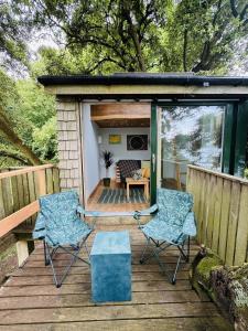 two chairs and a table on a wooden deck at Harbour view Tree House in Cobh