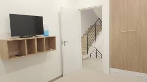 a living room with a television and a staircase at House Mare Blu in Balestrate