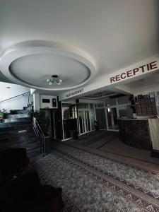 a lobby of a building with a sign on the ceiling at Hotel Mya in Bistriţa