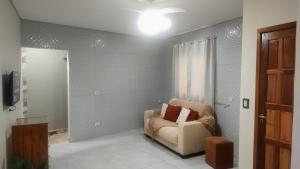a living room with a couch and a window at Refúgio com Churrasqueira na Praia in Bertioga