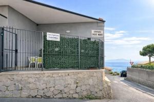 a building with a fence with a green hedge at Casa Concettina in Ercolano