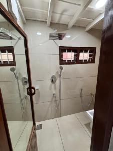 a bathroom with a shower with a glass door at Chettiparambil Heritage in Cochin