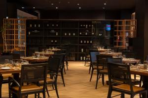 a dining room with tables and chairs with wine bottles at Enjoy Punta del Este in Punta del Este