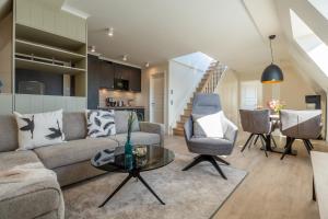 a living room with a couch and a table at Apartmenthaus Resort Kranichsruh in Fuhlendorf