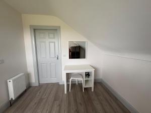 a white desk with a chair in a room at Lar Na Cluaine in Kilmurry