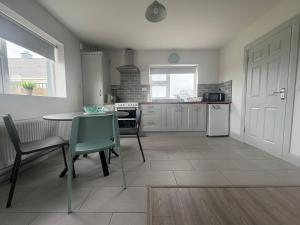 a kitchen with a table and chairs and a table and a table and a kitchen at Lar Na Cluaine in Kilmurry