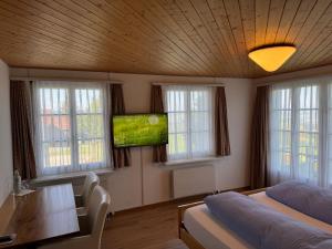 a bedroom with two beds and a flat screen tv at Hirschen Wald - Gasthaus & Bäckerei in Wald