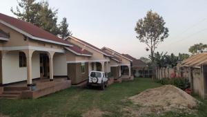 a row of houses with a car parked in the yard at CJ Apartments in Kapchorwa