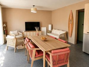 a living room with a wooden table and chairs at Villa Mezzanotte Le Brusc 80m de la mer - Climatisation-Piscine-Parking in Six-Fours-les-Plages
