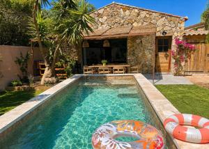 a swimming pool with an infront of a house at Villa Mezzanotte Le Brusc 80m de la mer - Climatisation-Piscine-Parking in Six-Fours-les-Plages