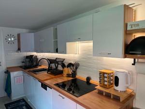 a kitchen with white cabinets and a counter top at Apartmán U našich in Jeseník