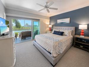 a bedroom with a bed and a television and a balcony at Old Marco Inne 403 in Marco Island +21 photos