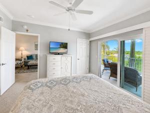 a bedroom with a bed and a television and a balcony at Old Marco Inne 403 in Marco Island