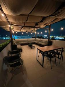 a living room with a table and chairs and a couch at Rezende Suítes in Balneário Camboriú