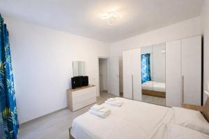 a white bedroom with a bed and a television at Casa Concettina in Ercolano