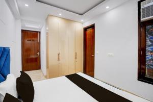 a bedroom with a white bed and wooden cabinets at Hotel O Maxico in New Delhi +23 photos