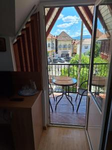 a kitchen with a table and a balcony with a view at Vila Simona in Călimăneşti