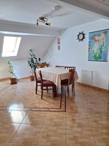 a dining room with a table and chairs and a clock at Vila Simona in Călimăneşti