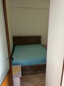 a small bedroom with a bed in a room at Eljo Apartment in Asim Zeneli