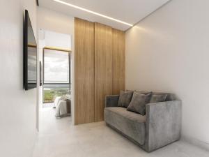 a living room with a gray couch and a window at Apartamento Beach Resort in Salinópolis