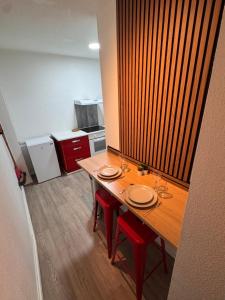 a table in an office with red chairs and a kitchen at Écrin de barr in Barr