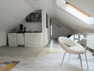 a white kitchen with a chair and a table at Appartement am Bach in Bad Berneck im Fichtelgebirge