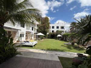a house with a yard with a couch and umbrella at Inn Tribus Hotel in Flecheiras