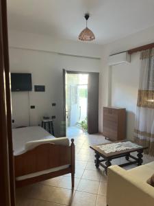 a bedroom with a bed and a couch and a table at Eljo Apartment in Asim Zeneli